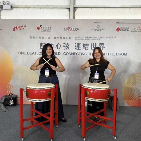 Ana Pista of ArdentComm trying out the drums with a friend during the event