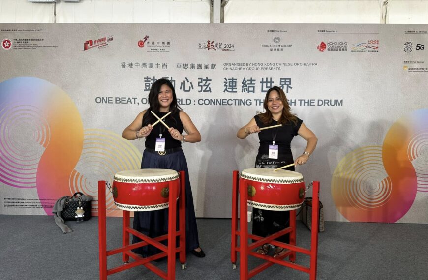 Ana Pista of ArdentComm trying out the drums with a friend during the event