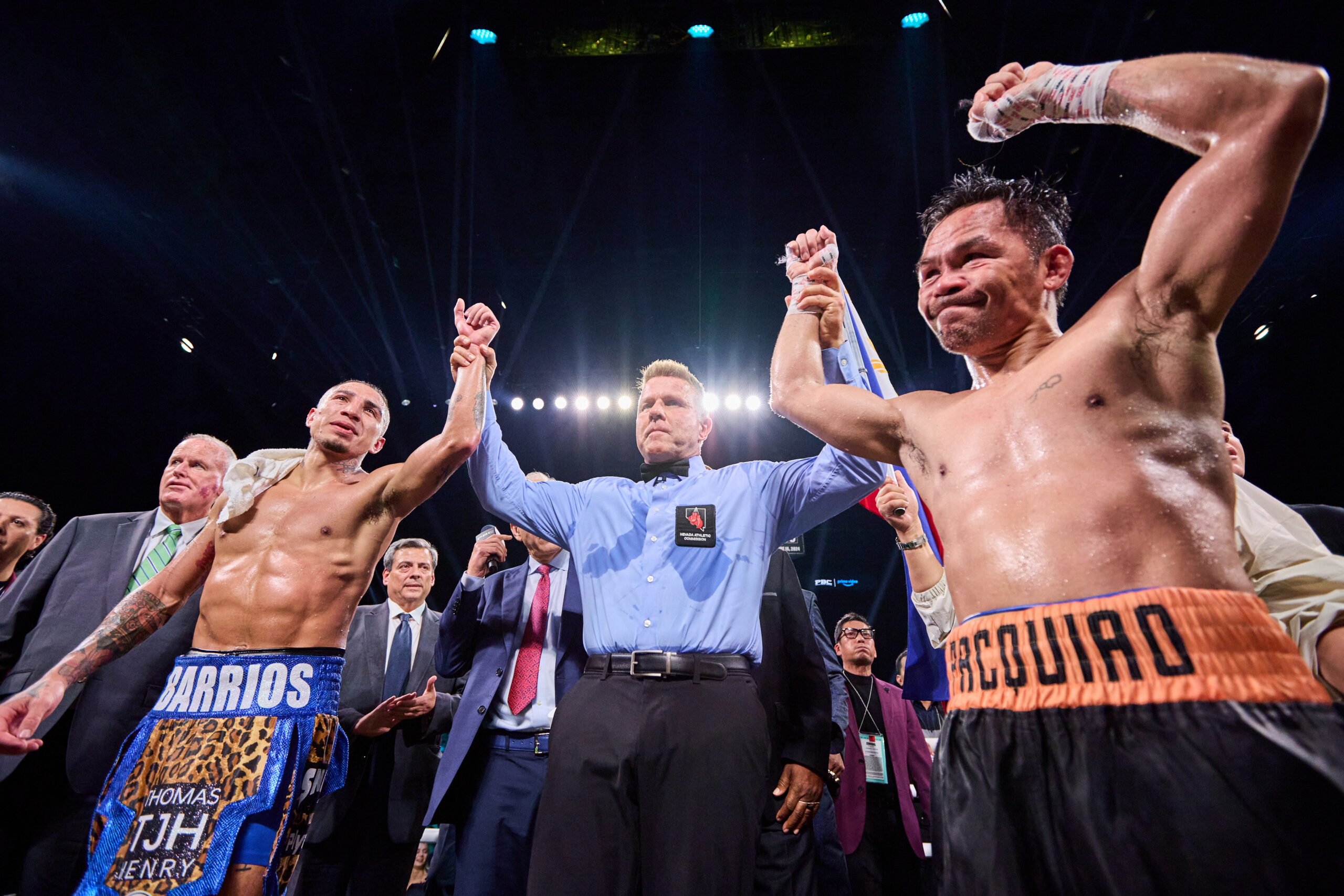 A referee raises the hands of both Manny Pacquiao and Mario Barrios after their fight was declared a majority draw