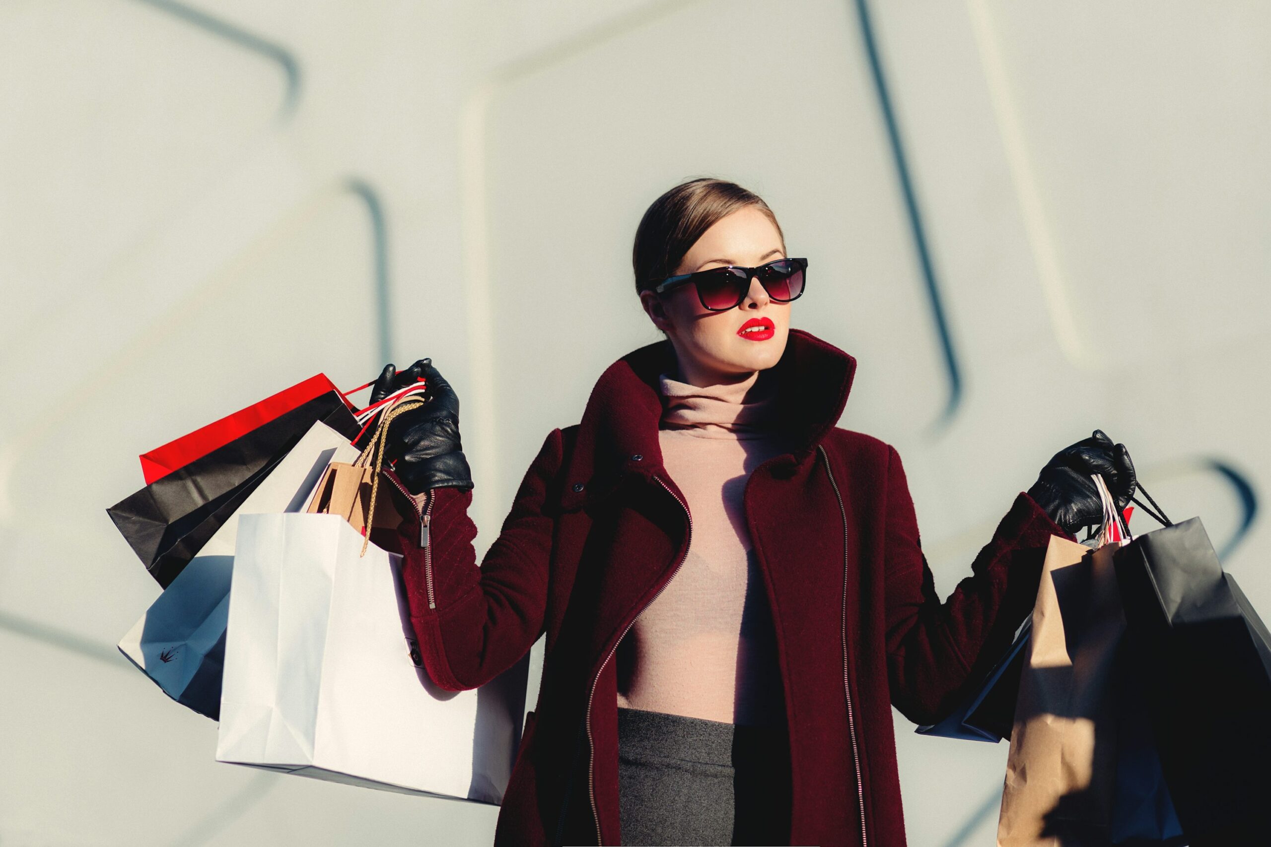 Image of a woman in a powerful outfit with shopping bags in her hands illustrates how fashion and dressing can affect one's mindset and behavior