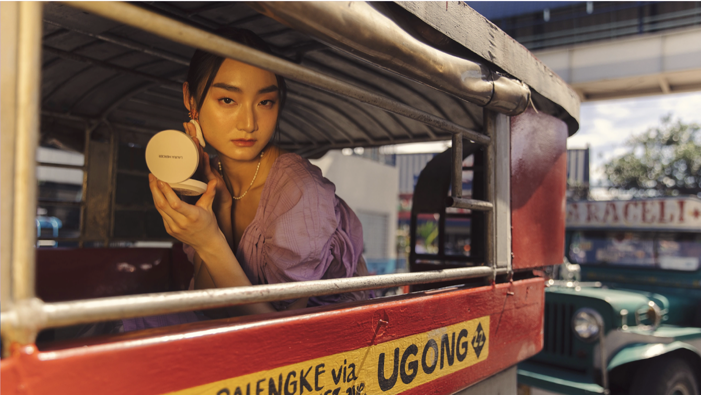A girl applying skin-care products inside a jeepney to achieve climate-proof beauty