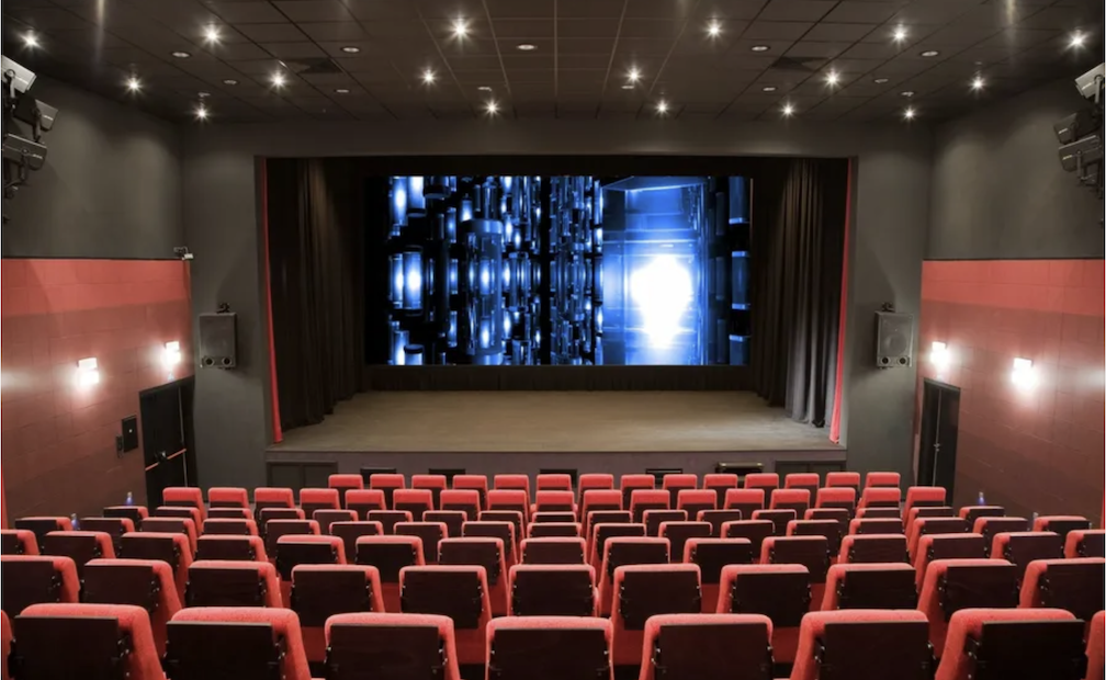 A large screen with seats inside one of the dimly lit cinemas in Manila