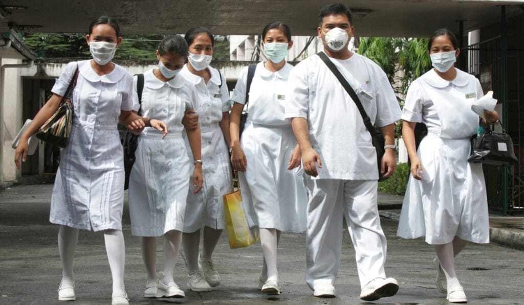 A group of Filipino nurses walking together towards OET building