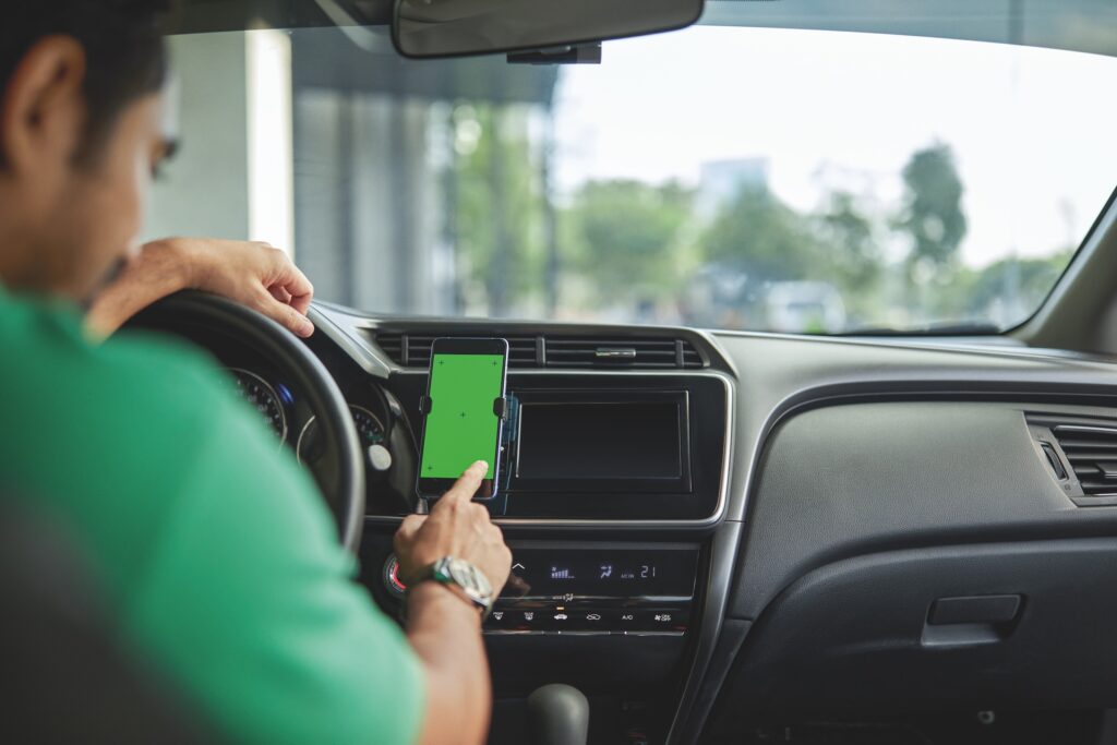 An inDrive partner driver checks the navigation screen on his car as he prepares to ride toward smarter mobility