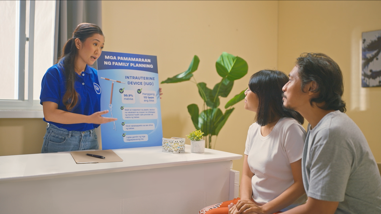 A health counselor talks to a husband and wife as part of TRUST championing reproductive health as a cornerstone of community well-being