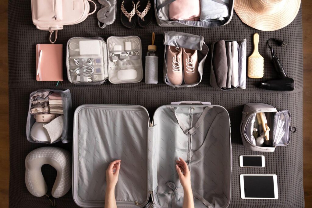 Travel tech for OFWs packed on a duffel bag: adapter, power bank, luggage tracker and earbuds